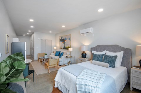 a bedroom with a large bed and a living room